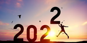 Silhouette-of-man-jumping-and-pushing-number-2022-into-the-sky-in-front-of-a-sunset